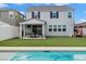 Spacious backyard featuring a covered patio, lush lawn, and a pristine pool at 2616 Tolmezzo St, Henderson, NV 89044