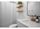 Clean bathroom featuring a vanity sink, modern faucet, and open shelving at 2616 Tolmezzo St, Henderson, NV 89044