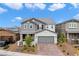 A two-story home with a gray color scheme, a two-car garage, and manicured landscaping at 2616 Tolmezzo St, Henderson, NV 89044