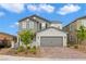 Charming two-story home featuring a gray exterior, brick driveway, and well-maintained landscaping at 2616 Tolmezzo St, Henderson, NV 89044