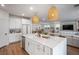 Open-concept kitchen with island, pendant lights, and stainless steel appliances, flowing into living and dining areas at 2616 Tolmezzo St, Henderson, NV 89044