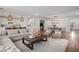 Spacious living room with a large sectional sofa, modern decor, and open layout to the kitchen and dining area at 2616 Tolmezzo St, Henderson, NV 89044