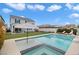 Stunning backyard pool and spa with lounge chairs, striped umbrella, and artificial grass at 2616 Tolmezzo St, Henderson, NV 89044