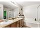 Bathroom with double sinks, soaking tub, shower, and wood-look flooring at 2664 Strichen Ave, Henderson, NV 89044