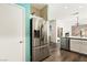 Spacious kitchen with stainless steel refrigerator, wood-look flooring, and view to dining area at 2664 Strichen Ave, Henderson, NV 89044