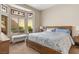Well-lit bedroom with large bed, bench, and window with stained glass detail at 2913 Laverton Dr, Las Vegas, NV 89134