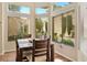 Dining area with a wood table and chairs under bright windows overlooking the landscaped yard at 2913 Laverton Dr, Las Vegas, NV 89134