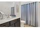 Bathroom featuring a single sink vanity with cabinets and blue and white striped curtains at 333 Aravalli Crest St, Henderson, NV 89015