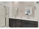 Modern bathroom with double sinks, stylish mirrors, and glass-enclosed shower at 333 Aravalli Crest St, Henderson, NV 89015
