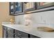 Bright kitchen counter area featuring quartz countertops, dark cabinetry, and modern decorative accents at 333 Aravalli Crest St, Henderson, NV 89015