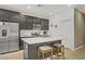 Modern kitchen with stainless steel appliances, a central island with seating, and stylish dark cabinets at 333 Aravalli Crest St, Henderson, NV 89015