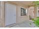 Neutral front door with textured stucco, window to the side, and covered porch at 3457 Abilene Gold Ct, Las Vegas, NV 89129