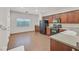 Open kitchen area with wood cabinets, modern appliances, and wood laminate floors at 3457 Abilene Gold Ct, Las Vegas, NV 89129