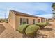 Backyard features a stucco exterior, green bushes, and easy-to-maintain rock ground cover at 3520 Kittiwake Rd, North Las Vegas, NV 89084