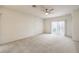 Spacious living room with neutral carpet, ceiling fan, and sliding doors for plenty of natural light at 3520 Kittiwake Rd, North Las Vegas, NV 89084