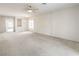 Expansive living room with neutral carpet, ceiling fan, and open layout for flexible furniture arrangement at 3520 Kittiwake Rd, North Las Vegas, NV 89084