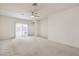 Spacious living room with neutral carpet, ceiling fan, and sliding doors for plenty of natural light at 3520 Kittiwake Rd, North Las Vegas, NV 89084