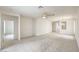 Expansive living room with neutral carpet, ceiling fan, and open layout for flexible furniture arrangement at 3520 Kittiwake Rd, North Las Vegas, NV 89084