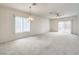 Bright living room features plush carpet, a ceiling fan, and a sliding glass door at 3520 Kittiwake Rd, North Las Vegas, NV 89084
