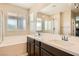 Bathroom boasting dual sinks, a bathtub, and a glass-enclosed shower, designed for ultimate relaxation at 39 Strada Fontana, Henderson, NV 89011