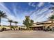 Welcoming community entrance with lush landscaping, mature palms, and circular driveway at 39 Strada Fontana, Henderson, NV 89011