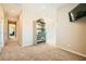 Hallway with neutral walls, carpet and a TV and storage shelves at 39 Strada Fontana, Henderson, NV 89011