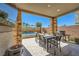 Inviting outdoor patio with a dining table, grill, and stone pillars at 39 Strada Fontana, Henderson, NV 89011