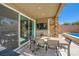 Covered patio with outdoor dining and media area near the pool at 39 Strada Fontana, Henderson, NV 89011
