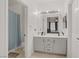 This bathroom features double sinks, neutral tile, and a shower behind a blue curtain at 3915 Palm Beach St # 201, Las Vegas, NV 89129