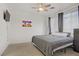This bedroom features neutral carpet, a ceiling fan, and a colorful wall art print at 3915 Palm Beach St # 201, Las Vegas, NV 89129