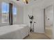 Bright bedroom featuring a ceiling fan, large window with curtains and doorway at 3915 Palm Beach St # 201, Las Vegas, NV 89129