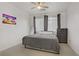 This bedroom features neutral carpet, a ceiling fan, and a colorful wall art print at 3915 Palm Beach St # 201, Las Vegas, NV 89129