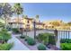 Community pool area surrounded by a fence, palm trees, and beautifully maintained bushes at 3915 Palm Beach St # 201, Las Vegas, NV 89129