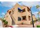 Attractive condo complex featuring a tan exterior, stairwell access, and beautiful desert landscaping at 4131 Gannet Cir # 389, Las Vegas, NV 89103