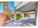 Covered patio and lawn with landscaped flower beds and views of mature palm trees at 4921 Lazy Day Ct, Las Vegas, NV 89131