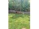 Backyard with green lawn and landscaping and two dogs relaxing near the stacked brick wall at 4921 Lazy Day Ct, Las Vegas, NV 89131
