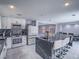Open kitchen with white cabinets, black marble counters, stainless appliances, and a large island at 5364 Awbury Ave, Las Vegas, NV 89110