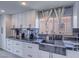Modern kitchen with black marble countertops, stainless steel sink, and white cabinets at 5364 Awbury Ave, Las Vegas, NV 89110
