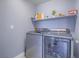 This large laundry room offers modern washer and dryer and convenient shelves for storage at 5364 Awbury Ave, Las Vegas, NV 89110