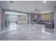 Open-concept layout with gray tile flooring, blending living room, dining, and kitchen seamlessly for modern living at 5364 Awbury Ave, Las Vegas, NV 89110