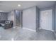 Bright living room featuring sleek tile flooring, a staircase, and a front door with glass accents at 5364 Awbury Ave, Las Vegas, NV 89110