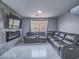 Comfortable living room featuring gray tile flooring, a fireplace, a media center, and a plush leather sofa at 5364 Awbury Ave, Las Vegas, NV 89110