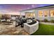 Outdoor patio features stone flooring, outdoor kitchen, a fire pit, lounge chairs, and covered seating area at 5715 Golden Chase Ct, Las Vegas, NV 89131
