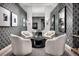 Cozy sitting area with patterned wallpaper, mirror, designer lighting, and seating around a dark table at 5715 Golden Chase Ct, Las Vegas, NV 89131