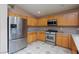 Kitchen with stainless steel appliances, oak cabinets and tile floor at 6133 Alderley Ct, North Las Vegas, NV 89081