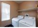 The laundry room has a window, washer, dryer, and built-in shelving at 6133 Alderley Ct, North Las Vegas, NV 89081