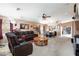 Spacious living room features carpet, large leather sofa, and ceiling fan at 6133 Alderley Ct, North Las Vegas, NV 89081