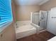 Bathroom featuring a soaking tub, shower, and tiled floors, great for relaxation at 6297 Peach Orchard Rd, Las Vegas, NV 89142
