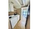 Bright laundry room featuring a washer, dryer, cabinets, and tile floor leading to a hallway at 6297 Peach Orchard Rd, Las Vegas, NV 89142