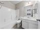 Bright bathroom features a shower-tub combo, white vanity, and ample lighting at 6403 Dundock Ave, Las Vegas, NV 89122
